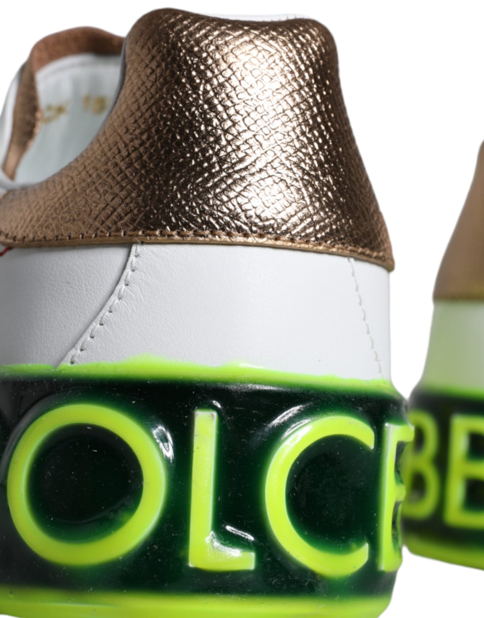 Pair of white sneakers with gold and green accents
