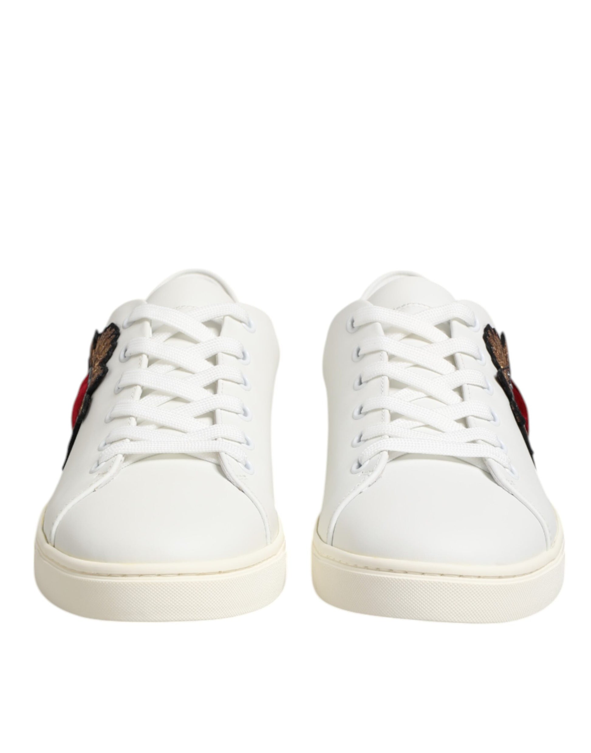 White leather sneakers with red heart patch on side, featuring laces and flat sole