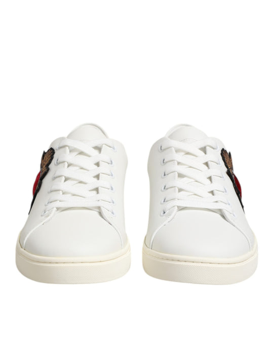 White leather sneakers with red heart patch on side, featuring laces and flat sole