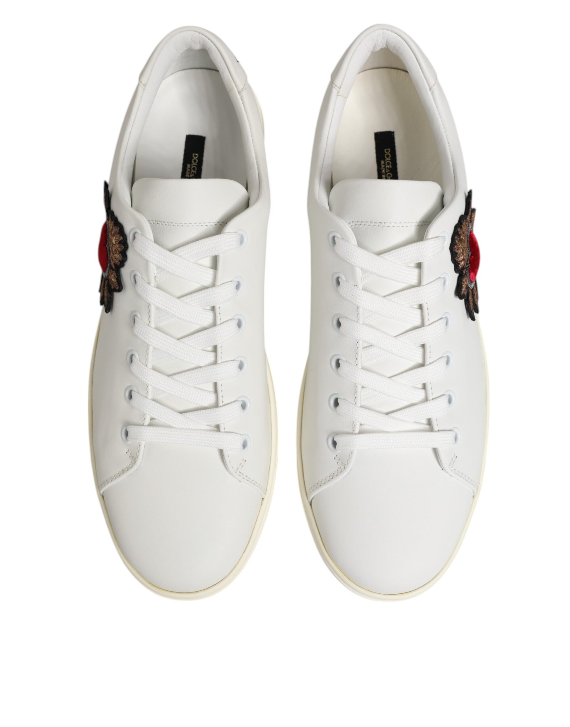 White leather sneakers with red heart patch on side, featuring laces and a low top