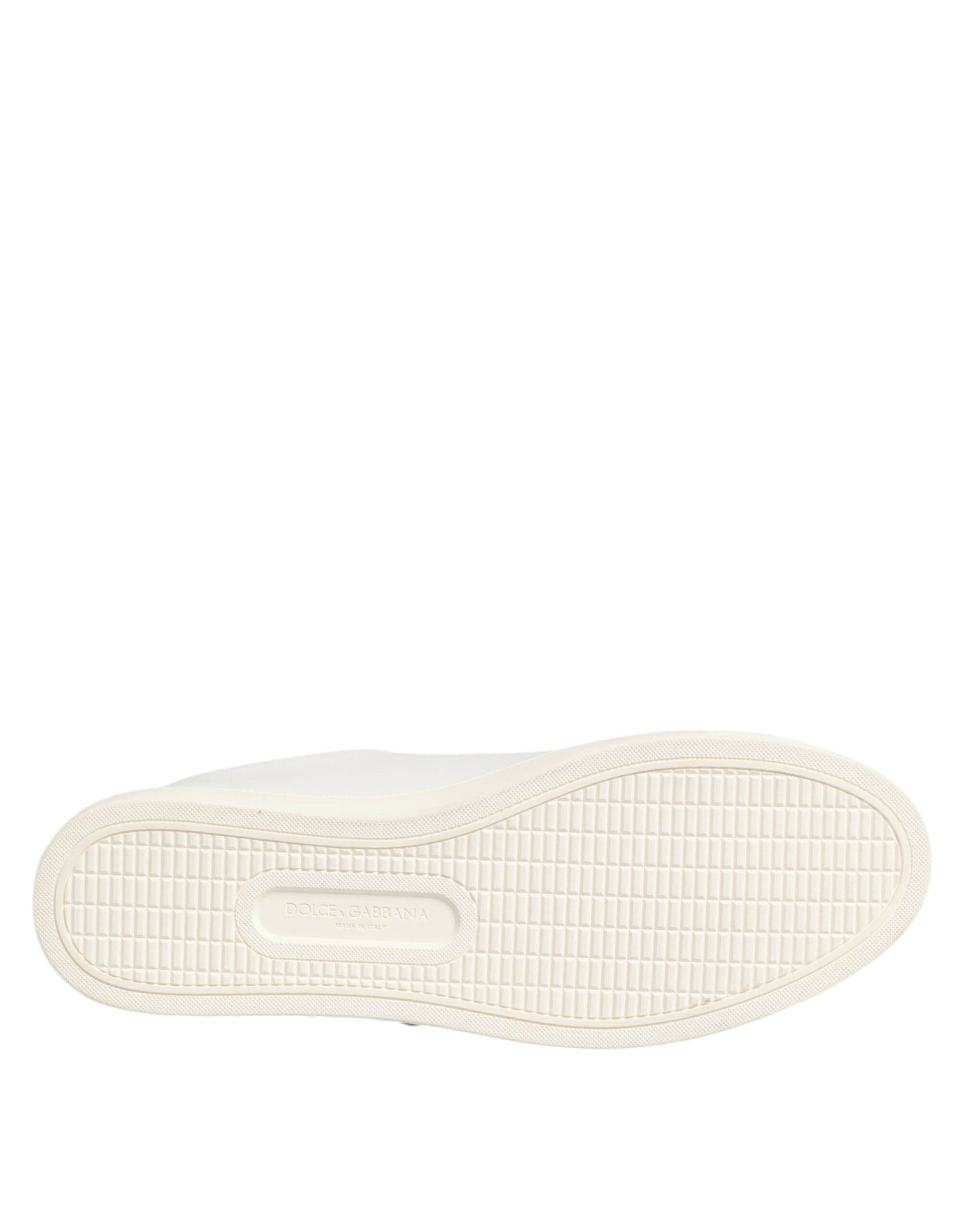 A pair of white leather sneakers with a sacred heart patch on the side