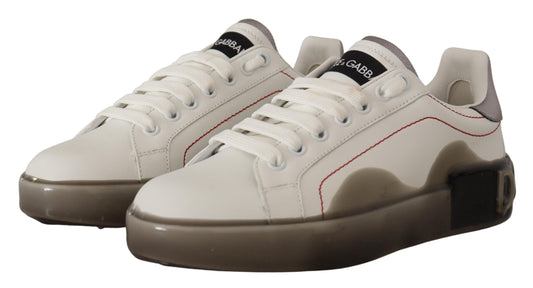 Pair of white sneakers with red accents and a black logo on the side