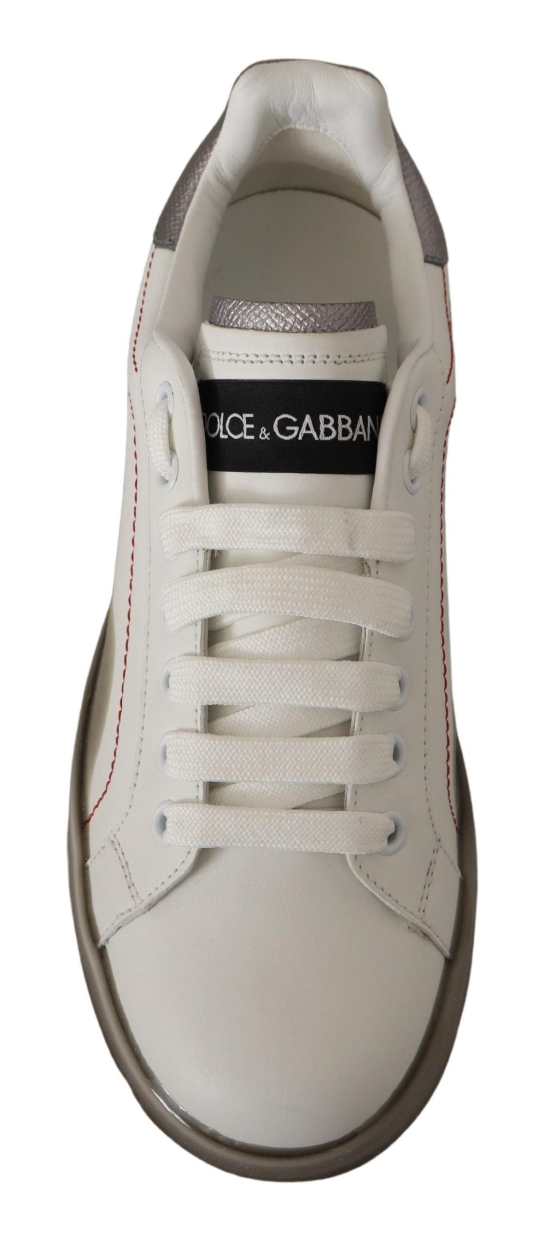 White sneaker with black laces and a red stripe on the side