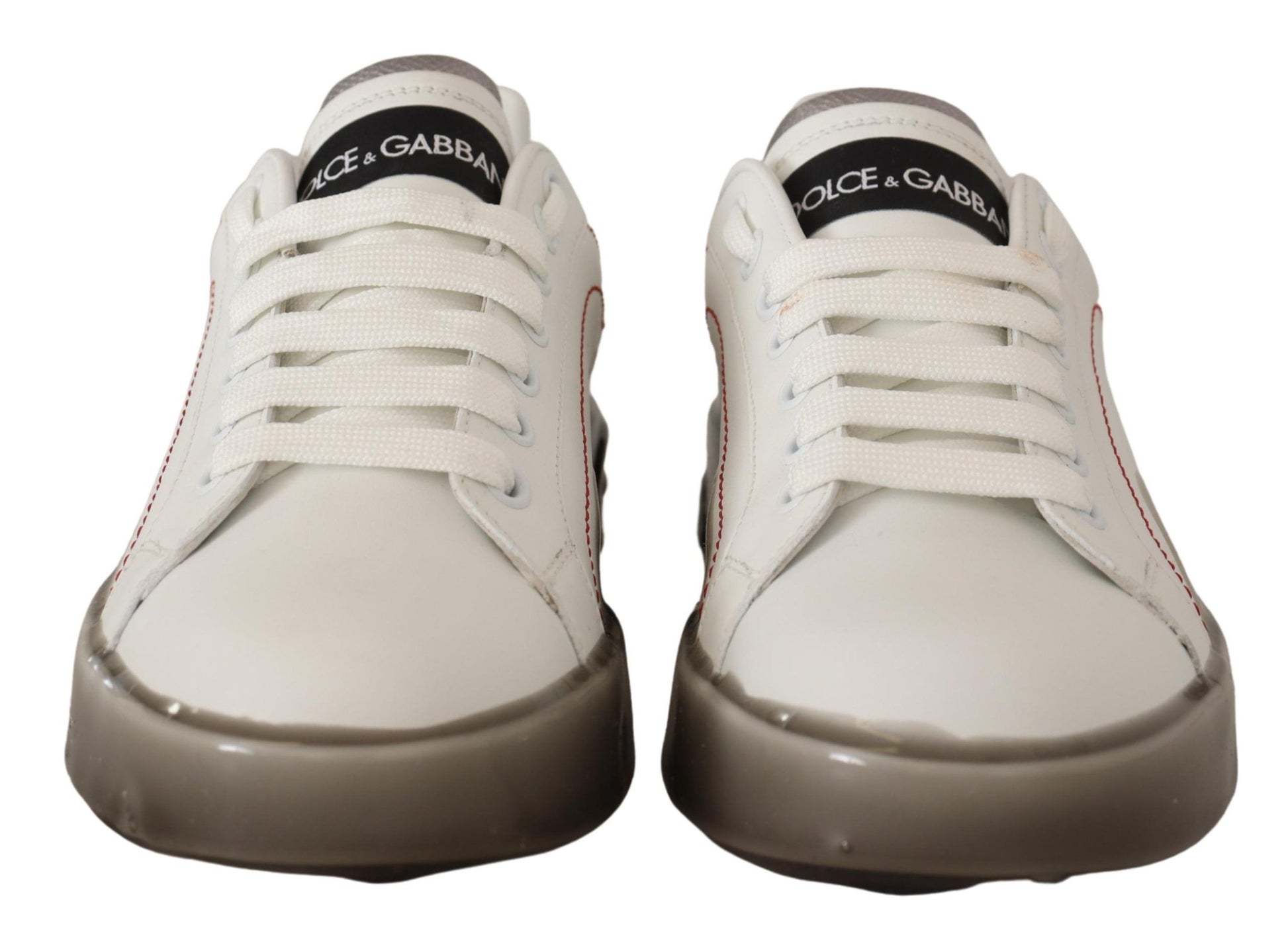 Pair of white sneakers with red accents and black laces