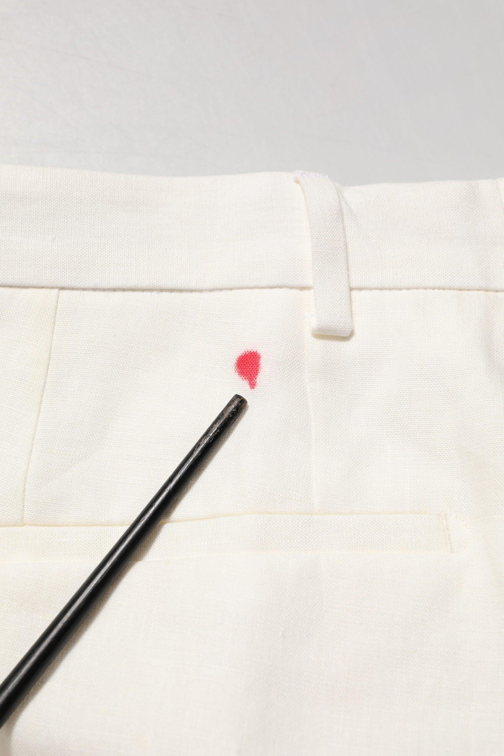 Black chopsticks on white linen pants