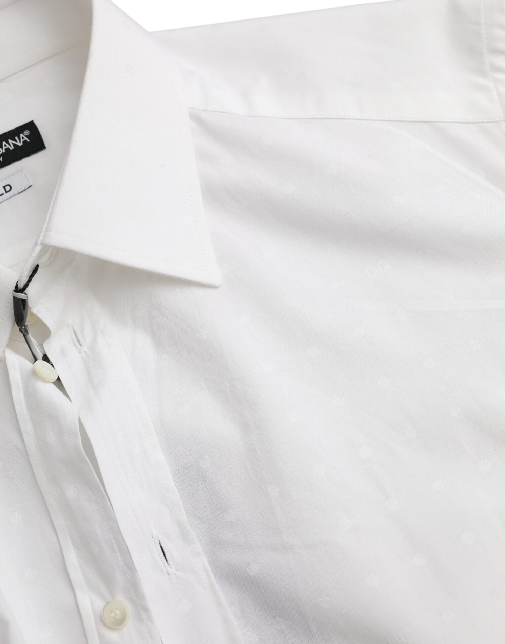 A white dress shirt with a gold logo on the left chest area