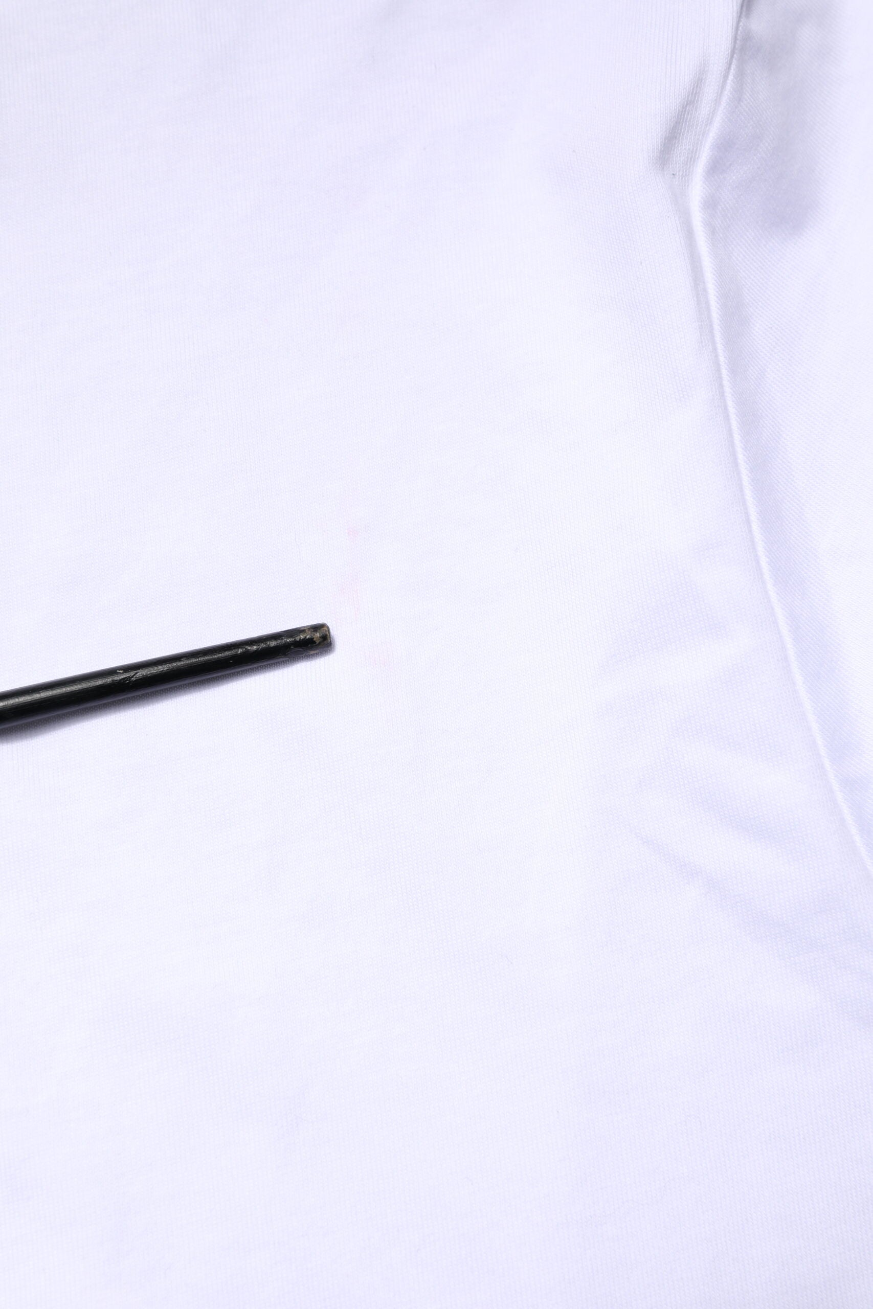 Small black pin on white fabric