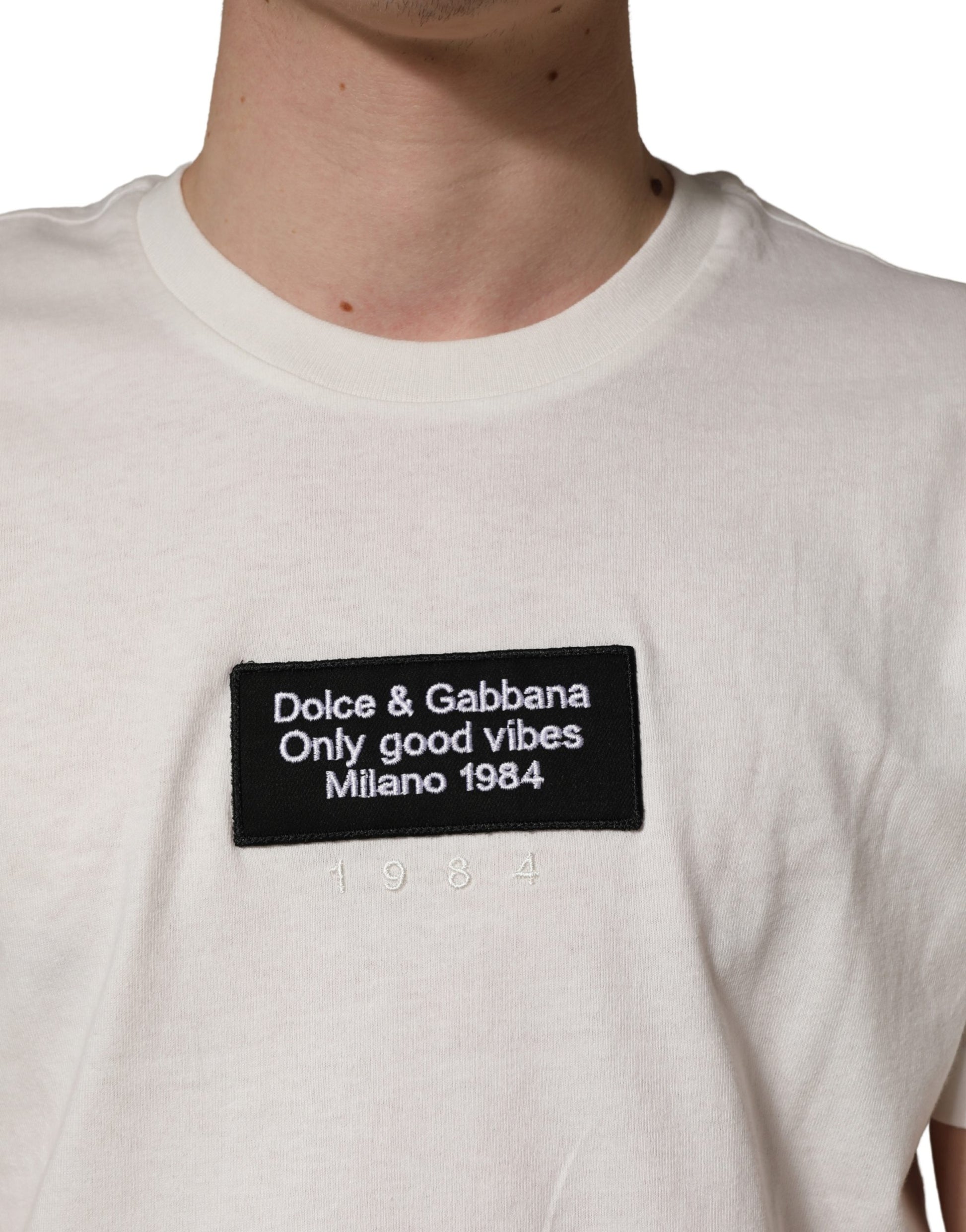 White t-shirt with black text reading "Dolce & Gabbana Only Good Vibes Milan 1984"