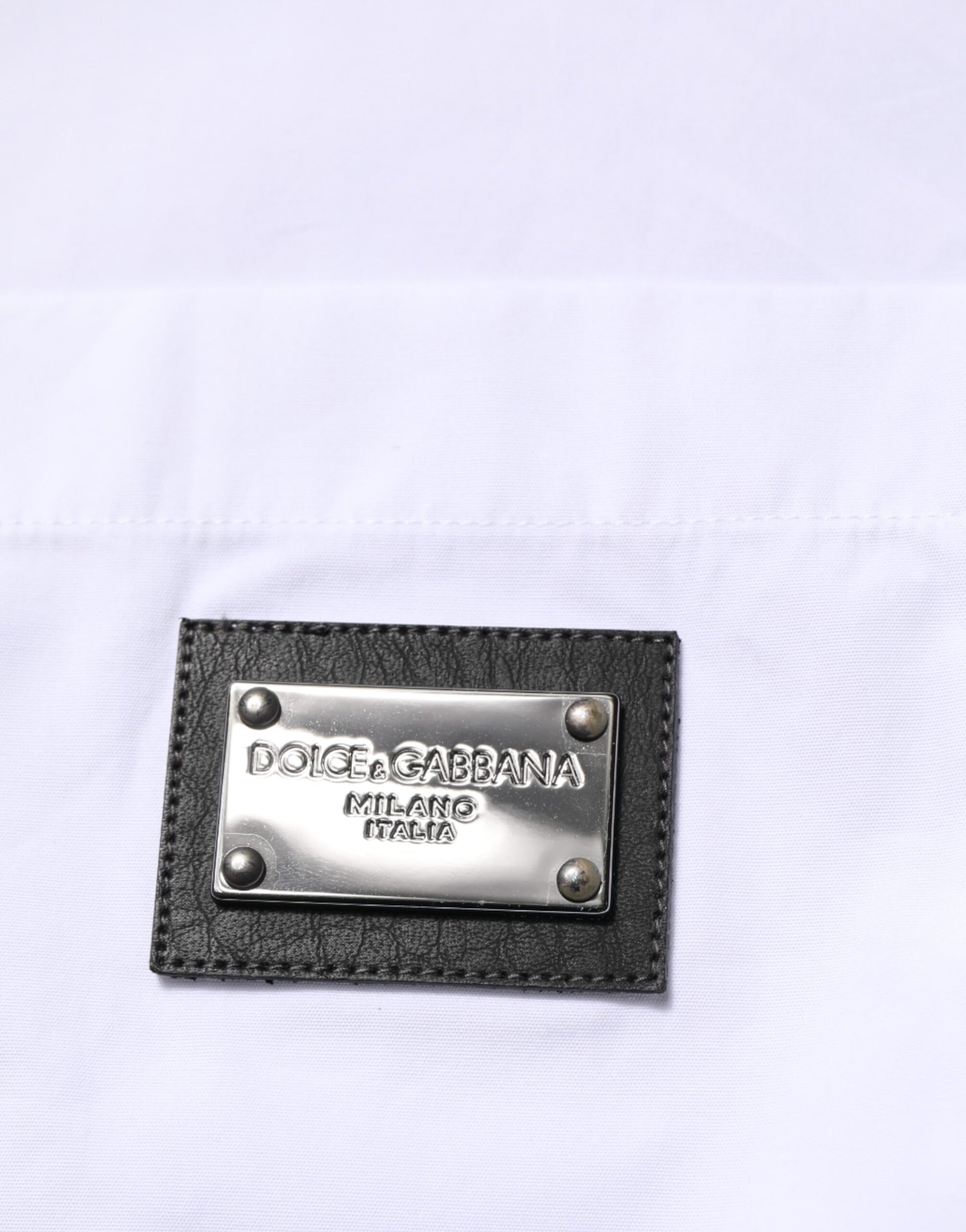 A black leather plaque with a silver metal border, featuring the Dolce & Gabbana logo