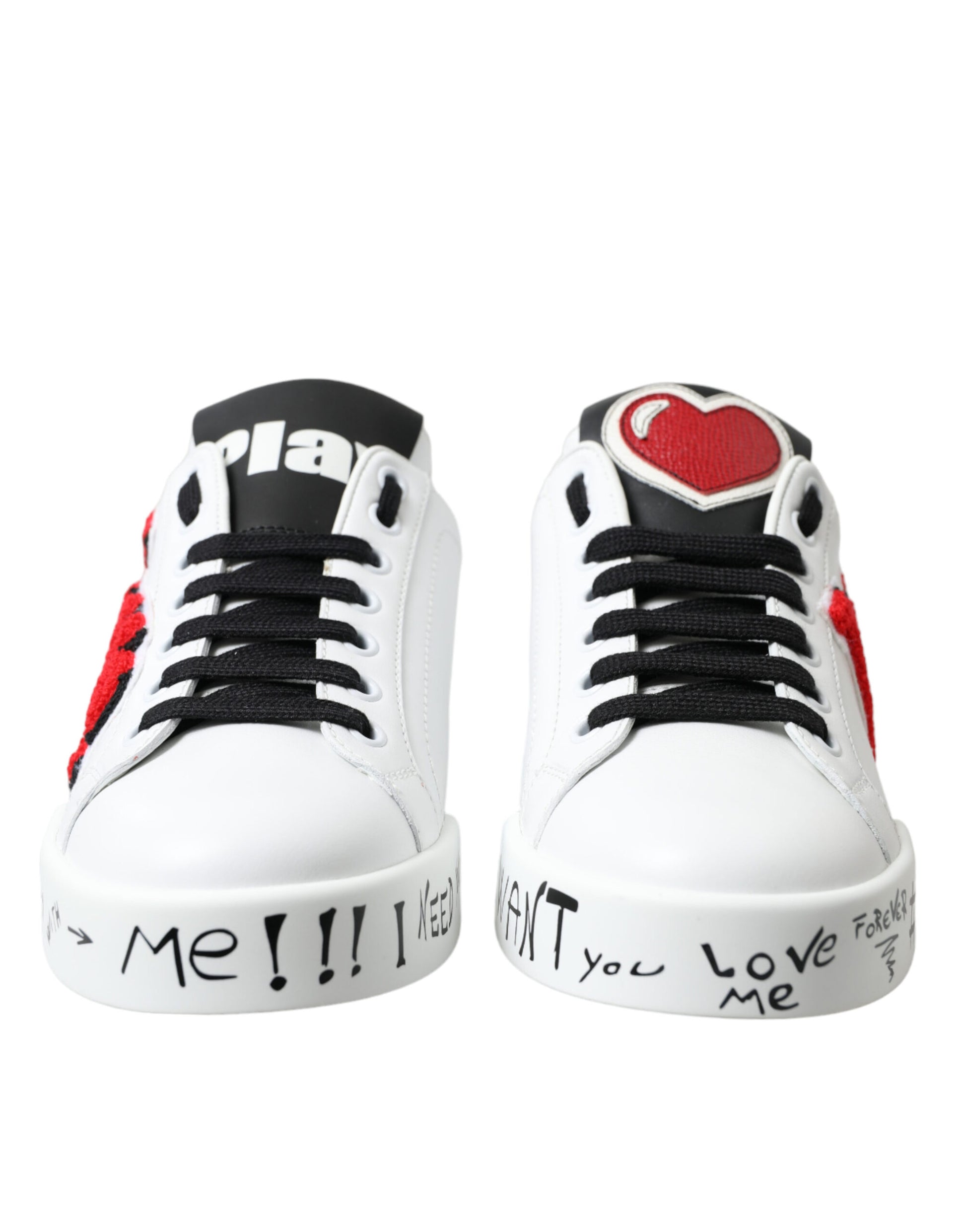 Pair of white sneakers with red and black accents featuring a heart design on the side and writing on the soles