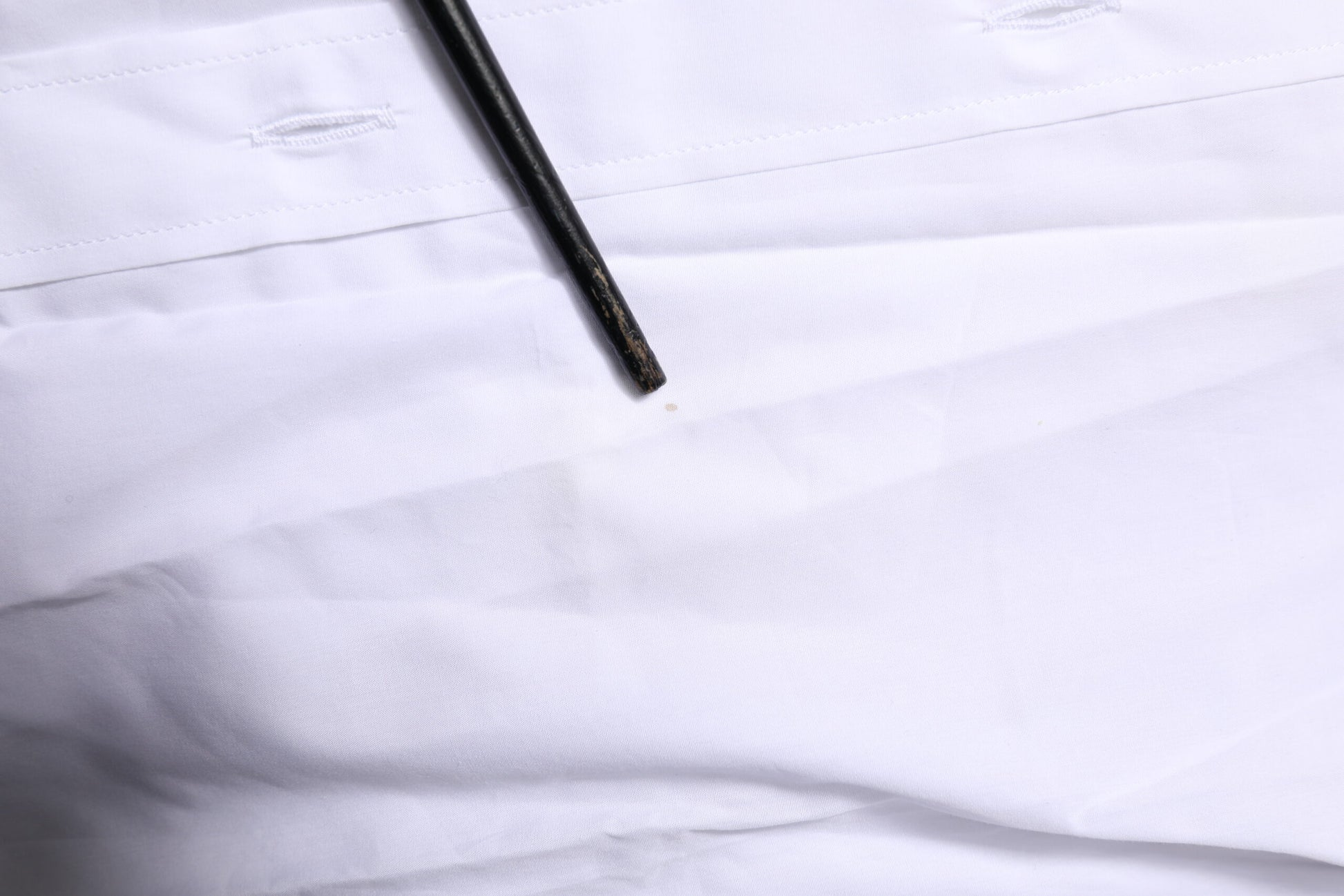 A white long sleeve dress shirt with a black button