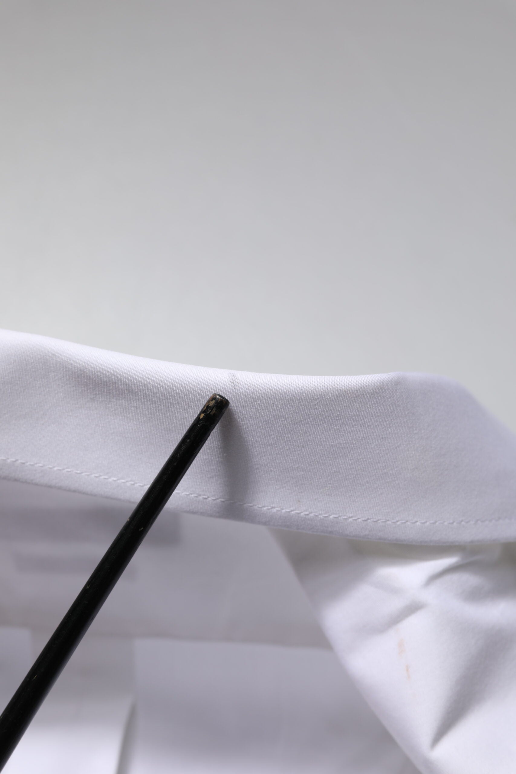 A black chopstick on a white dress shirt