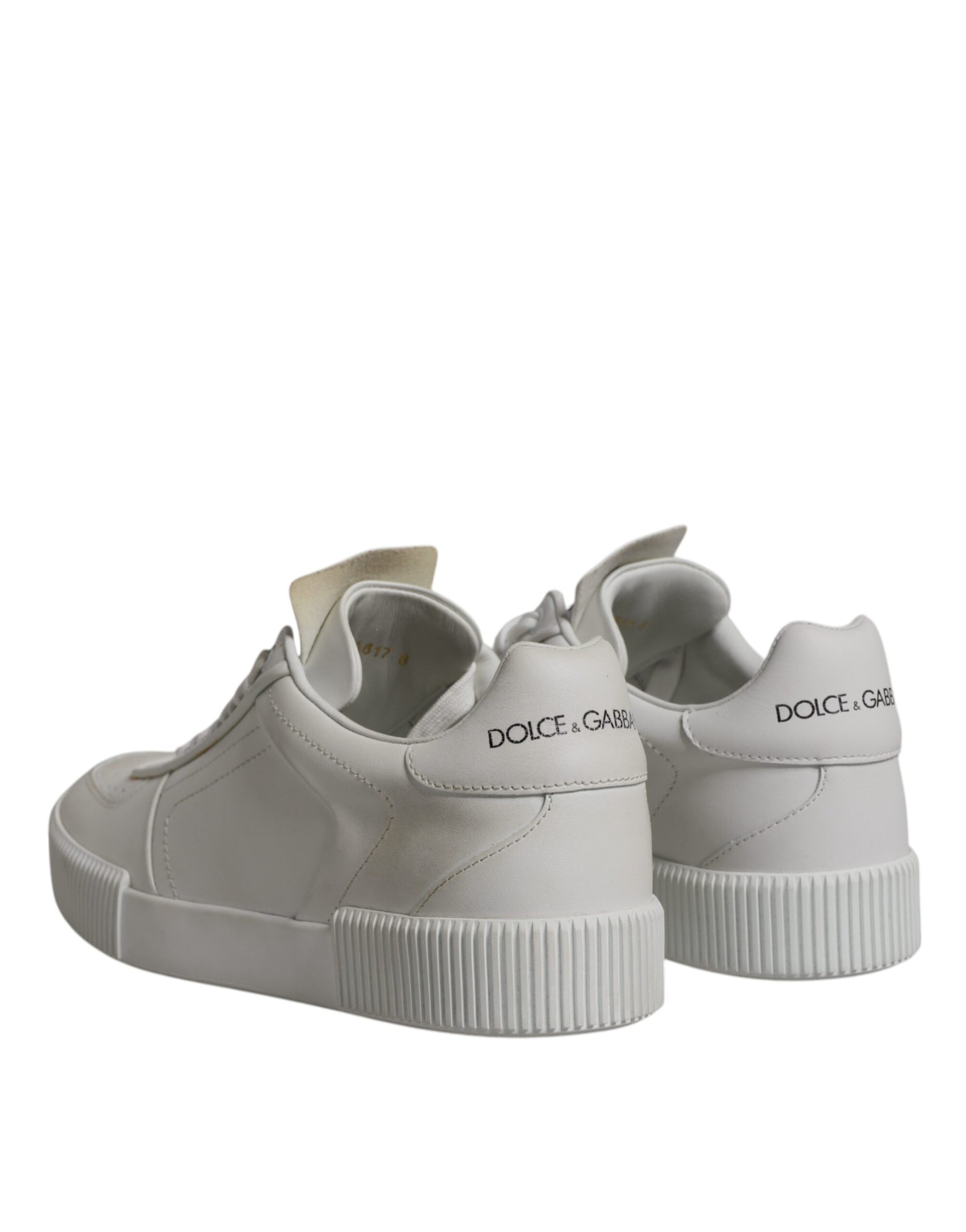 Pair of white leather sneakers with low top and chunky sole, featuring brand name on side