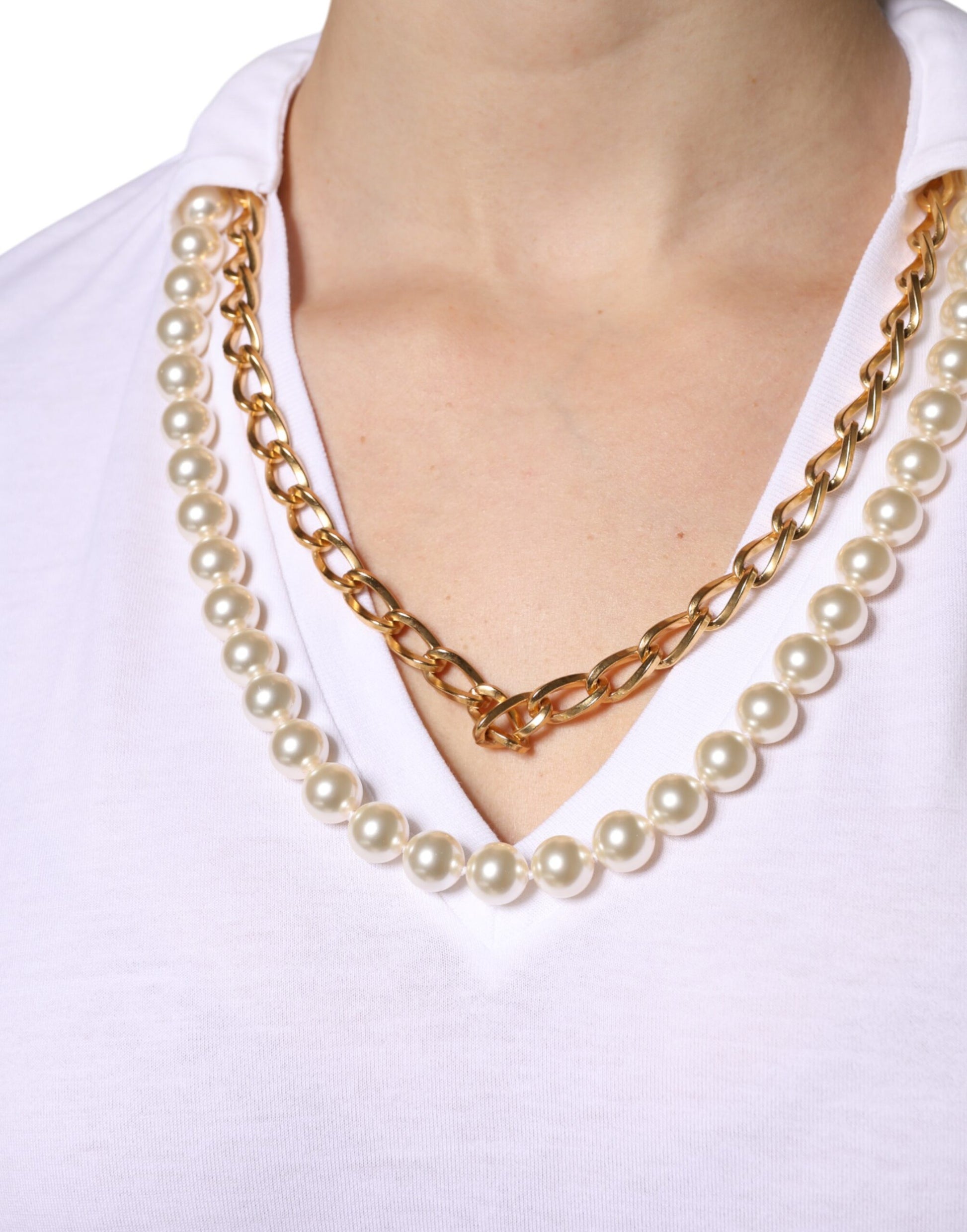Gold necklace with pearls around a person's neck
