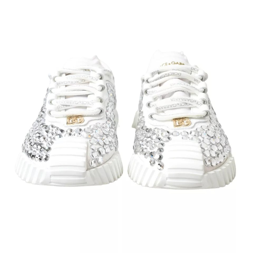 Pair of white sneakers with gold embellishments and laces