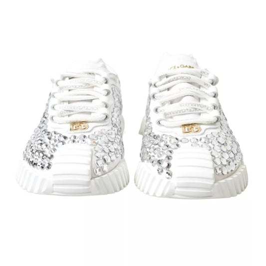 Pair of white sneakers with gold embellishments and laces