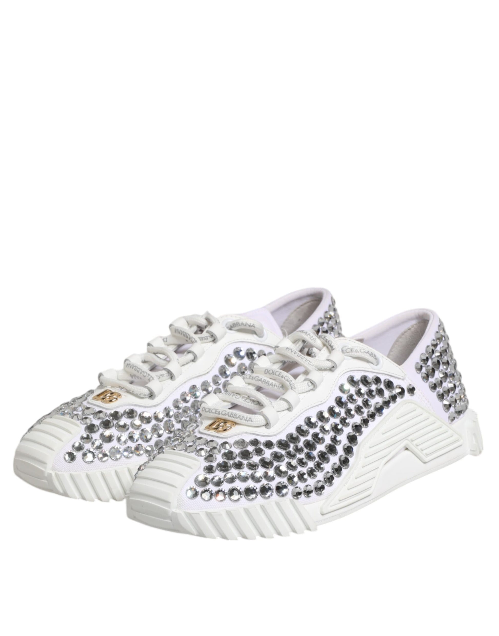 Pair of white sneakers with black and gold embellishments, featuring a canvas upper and leather accents