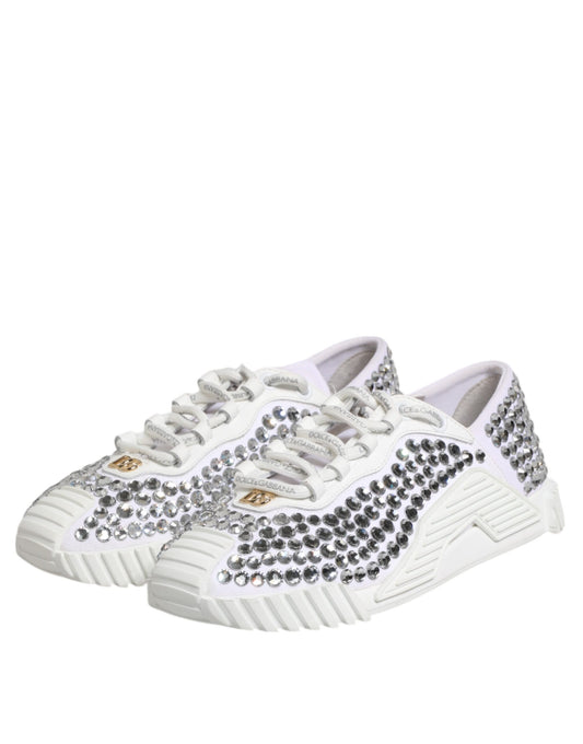 Pair of white sneakers with black and gold embellishments, featuring a canvas upper and leather accents