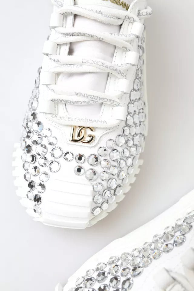 White sneakers with embellishments, featuring a logo on the side