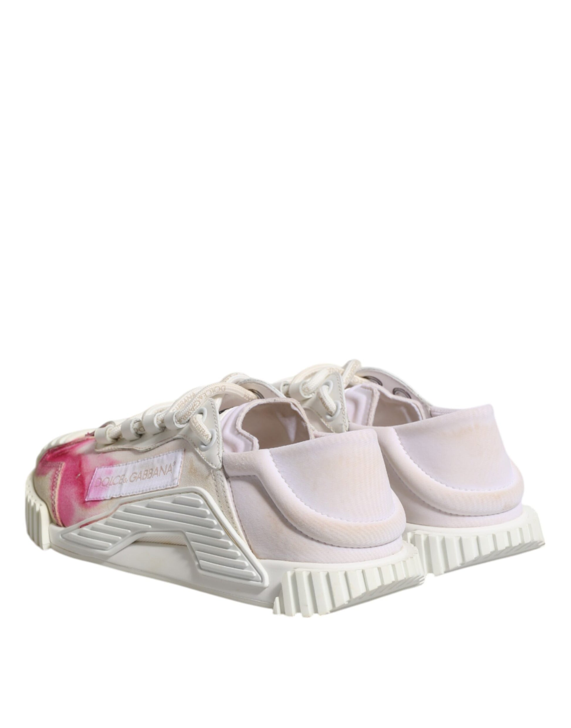 Pair of white lace-up sneakers with pink stains on the side