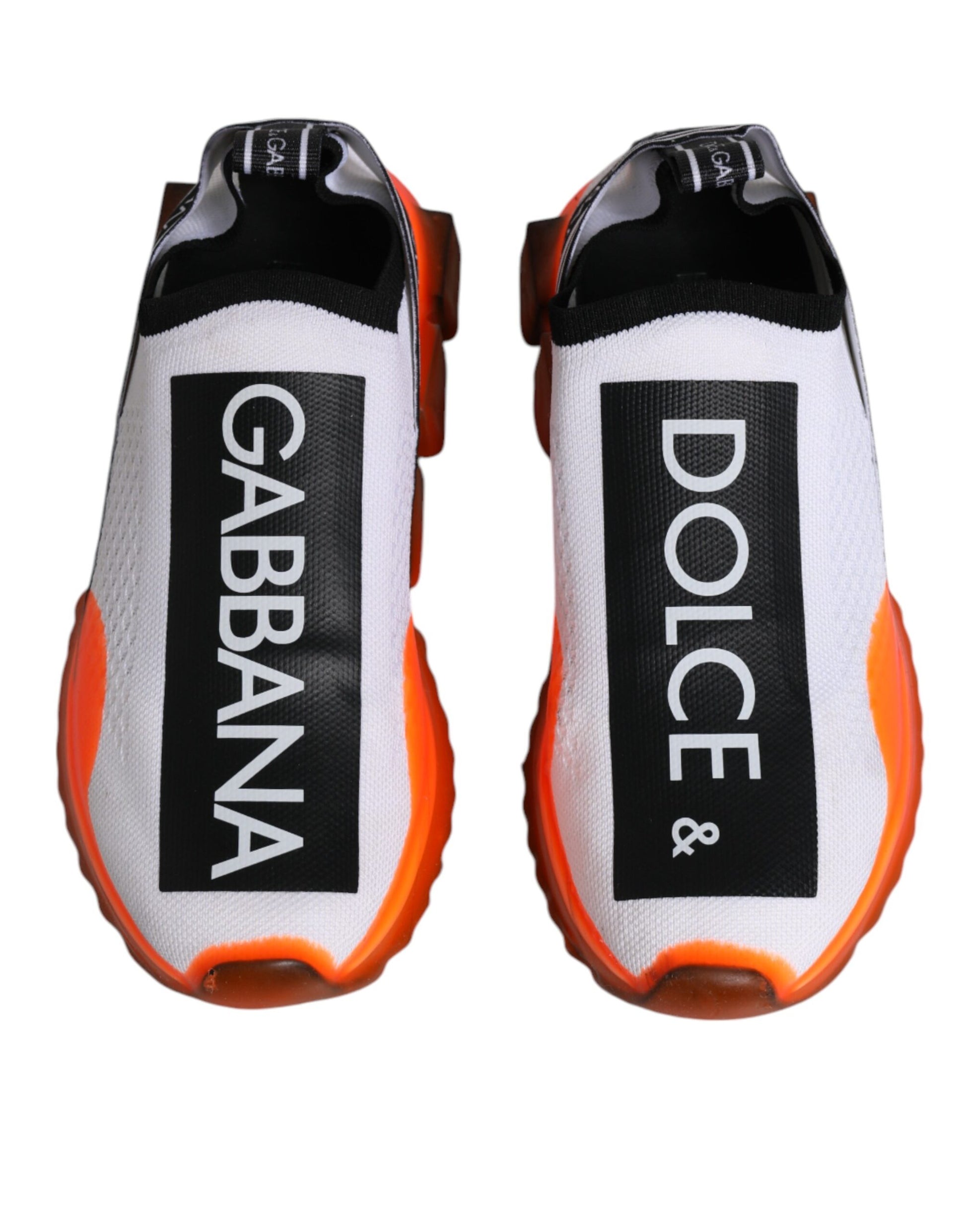Pair of white, orange, and black slip-on shoes with Dolce & Gabbana branding
