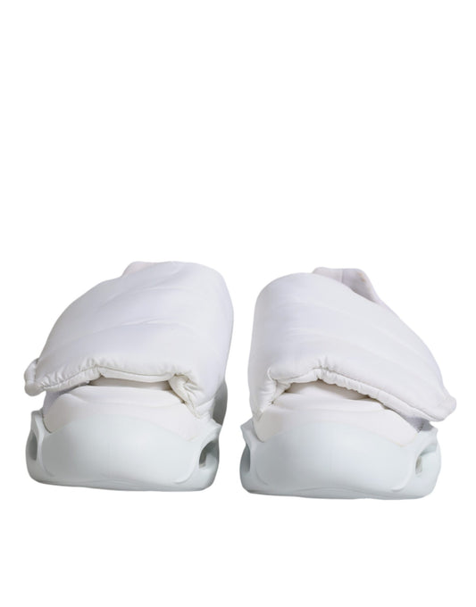 A pair of white padded fabric low top sneakers with a logo on the side