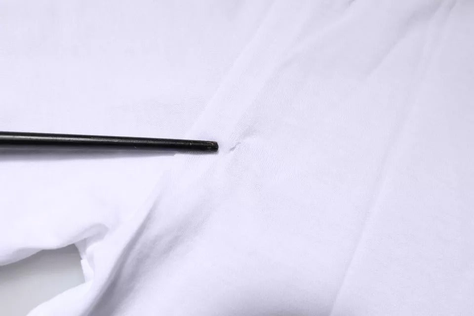 Black metal needle on white fabric