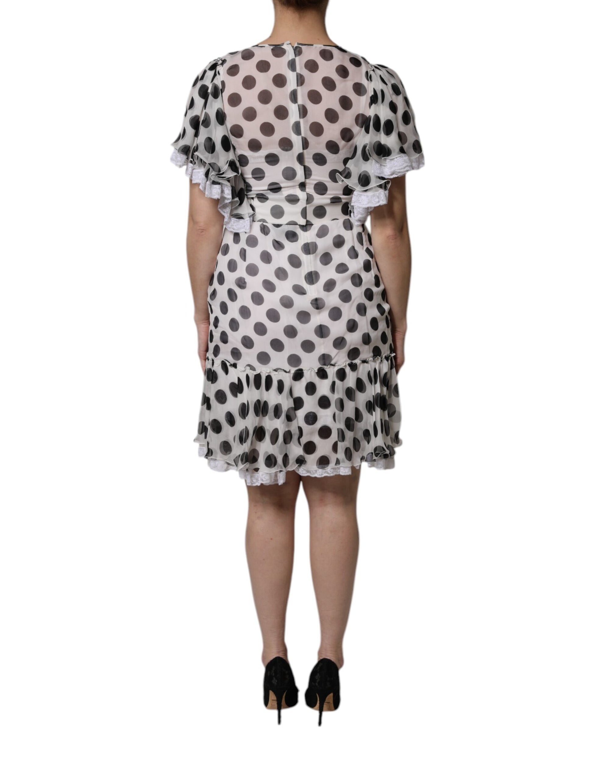 A white dress with black polka dots, featuring a silky blend fabric. It has an A-line cut and is designed by