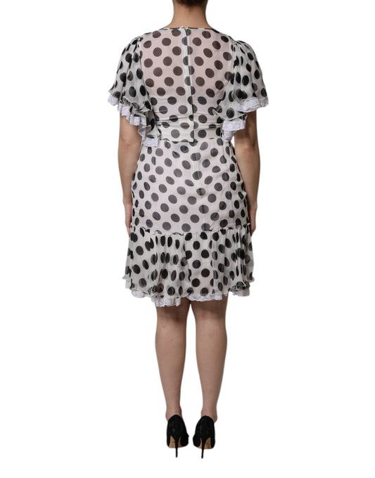 A white dress with black polka dots, featuring a silky blend fabric. It has an A-line cut and is designed by