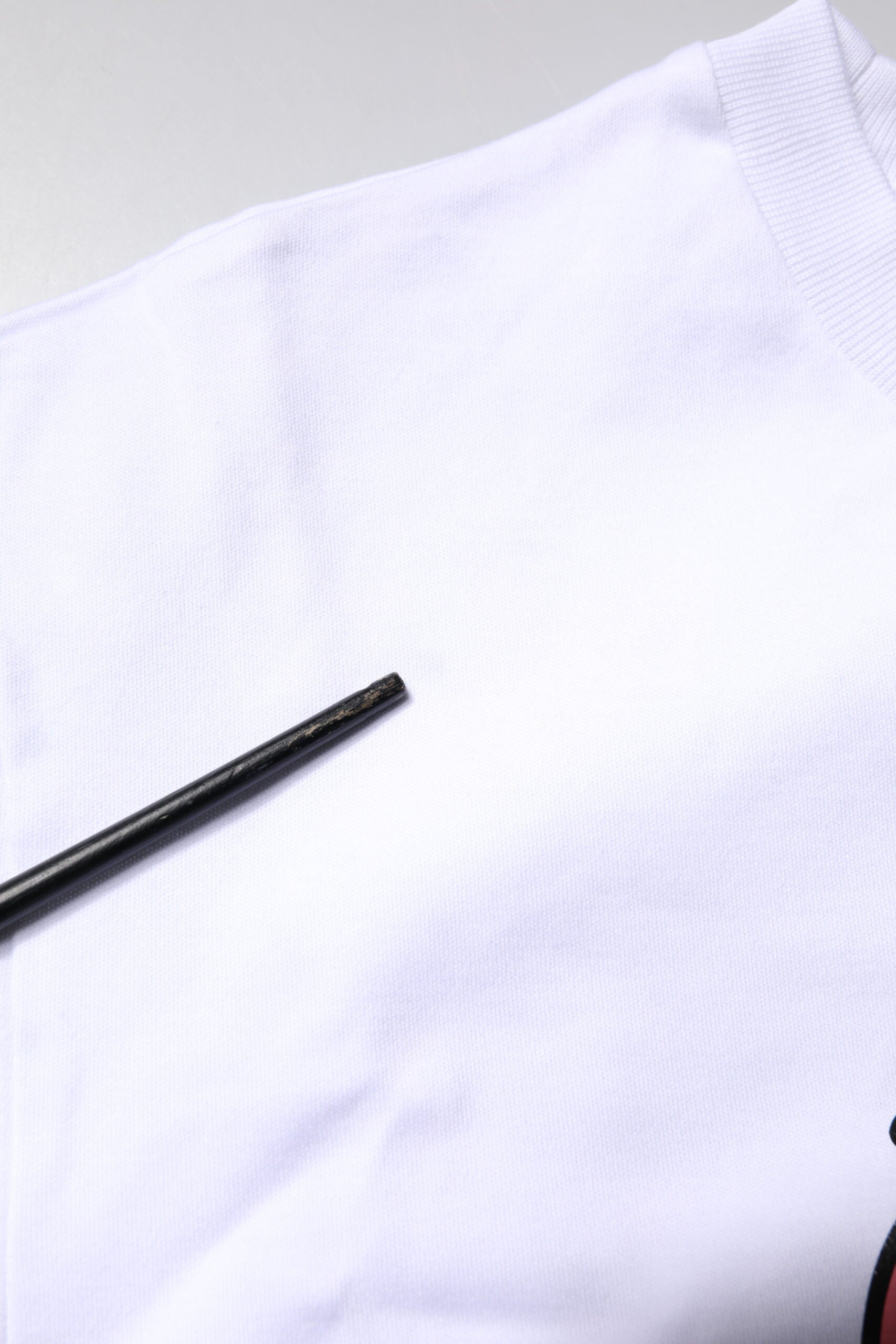 White t-shirt with black button