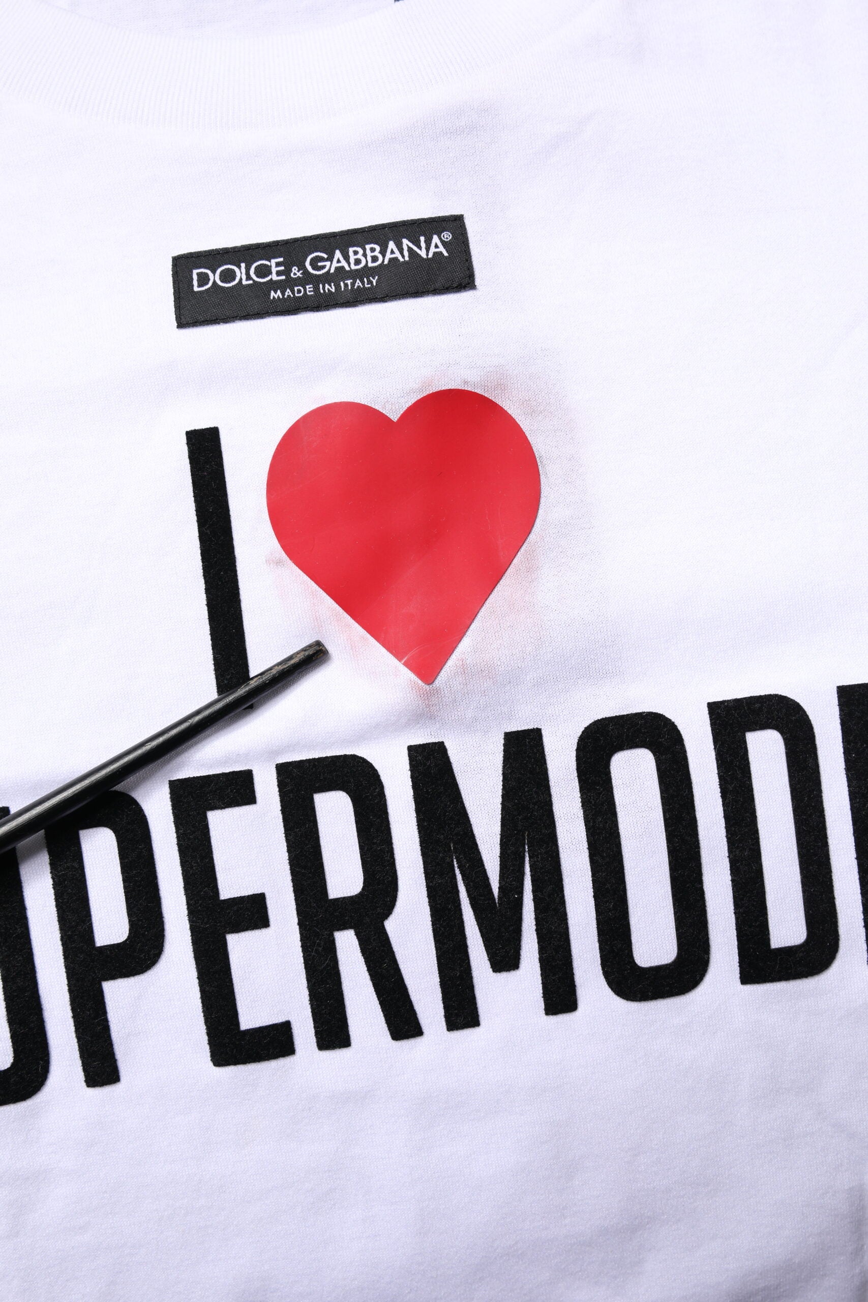 White t-shirt with black lettering and red heart graphic