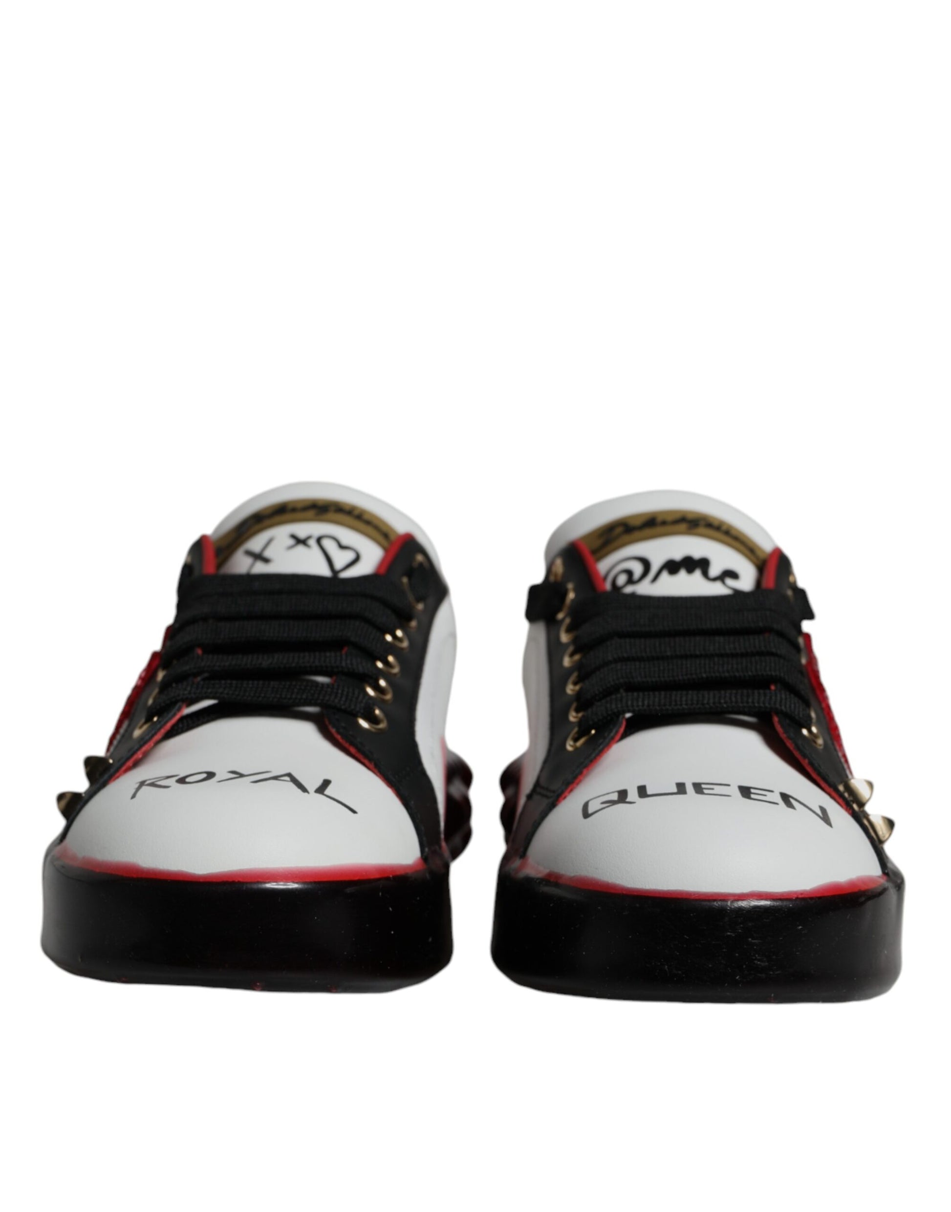 Pair of white sneakers with black laces and red accents