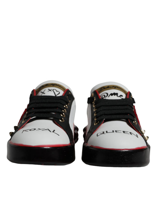 Pair of white sneakers with black laces and red accents