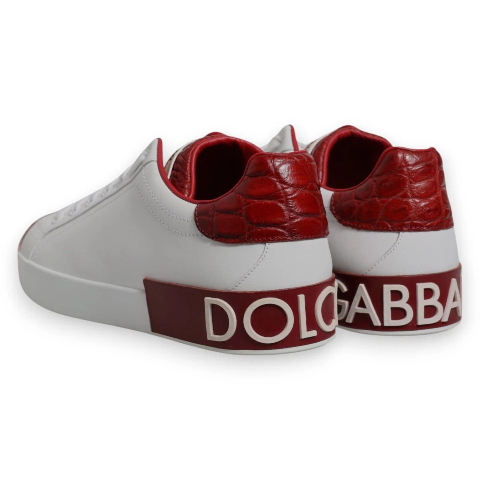 A pair of red and white leather sneakers with a logo on the side, featuring the brand name "Dolce & Gabbana"