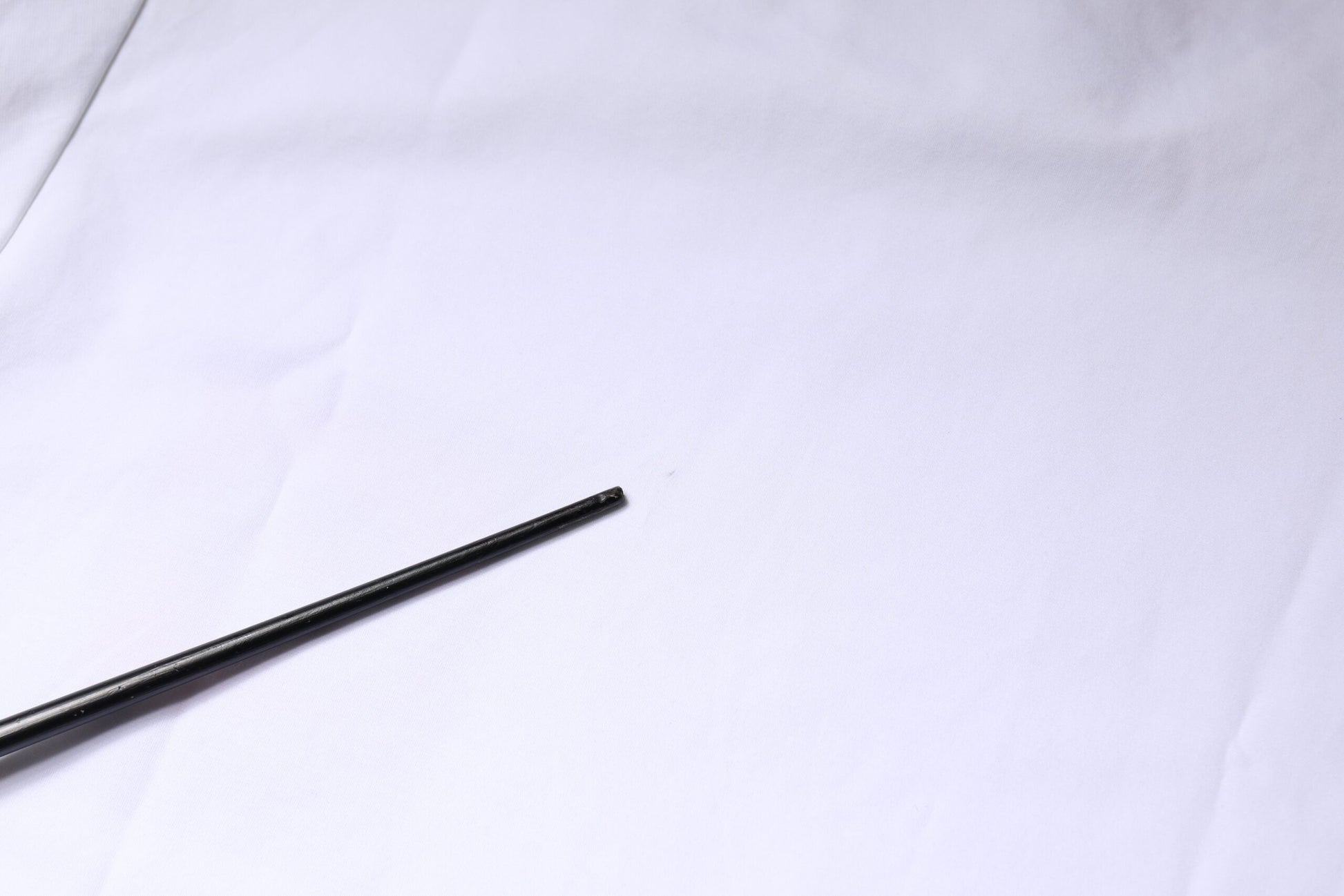Two black pencils on white surface