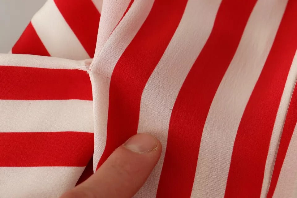 A close-up of a red and white striped fabric, which appears to be part of a dress