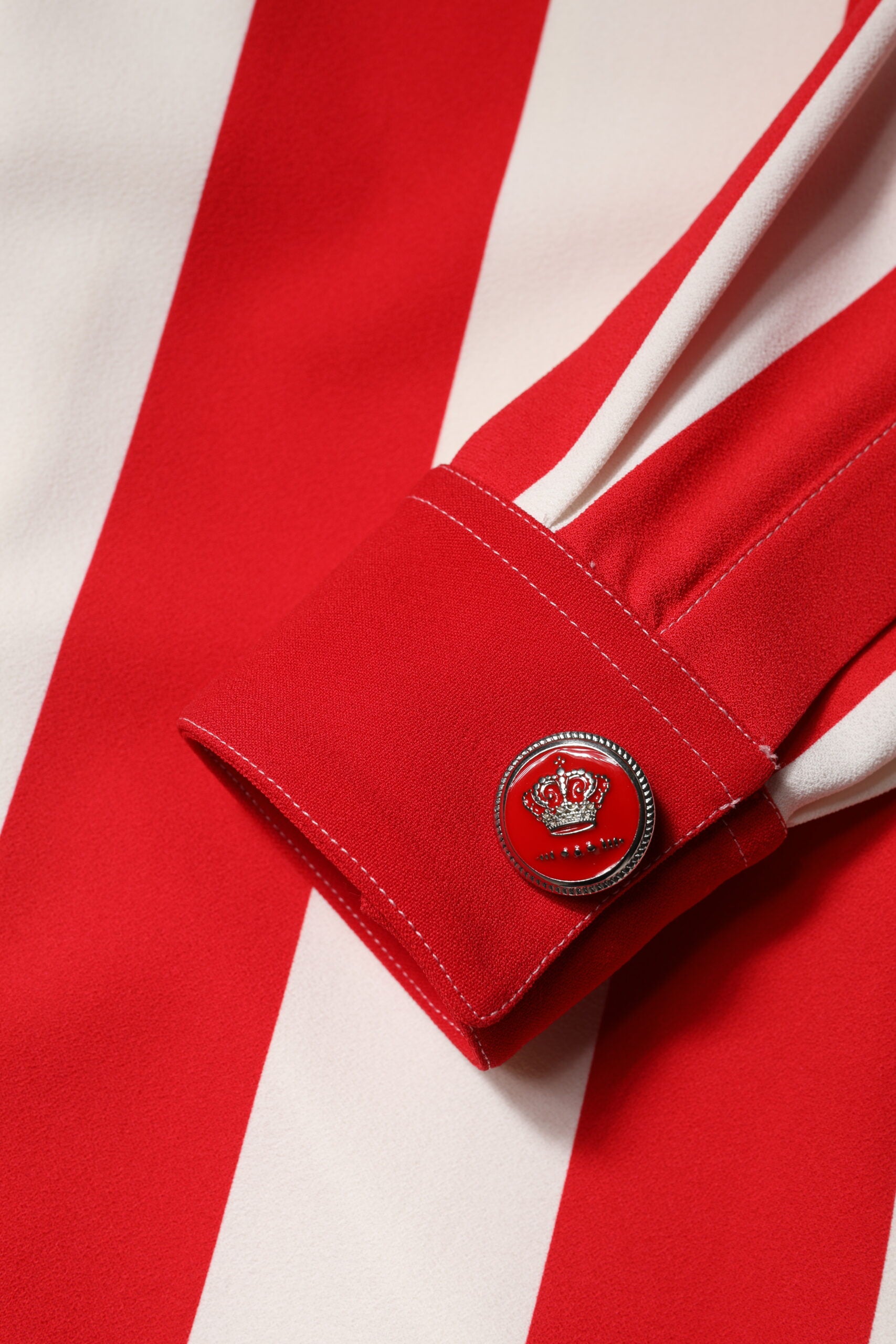 A red and white striped mini dress with long sleeves, featuring a logo on the left shoulder