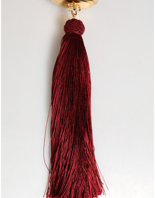 Red tassel hanging from a gold chain