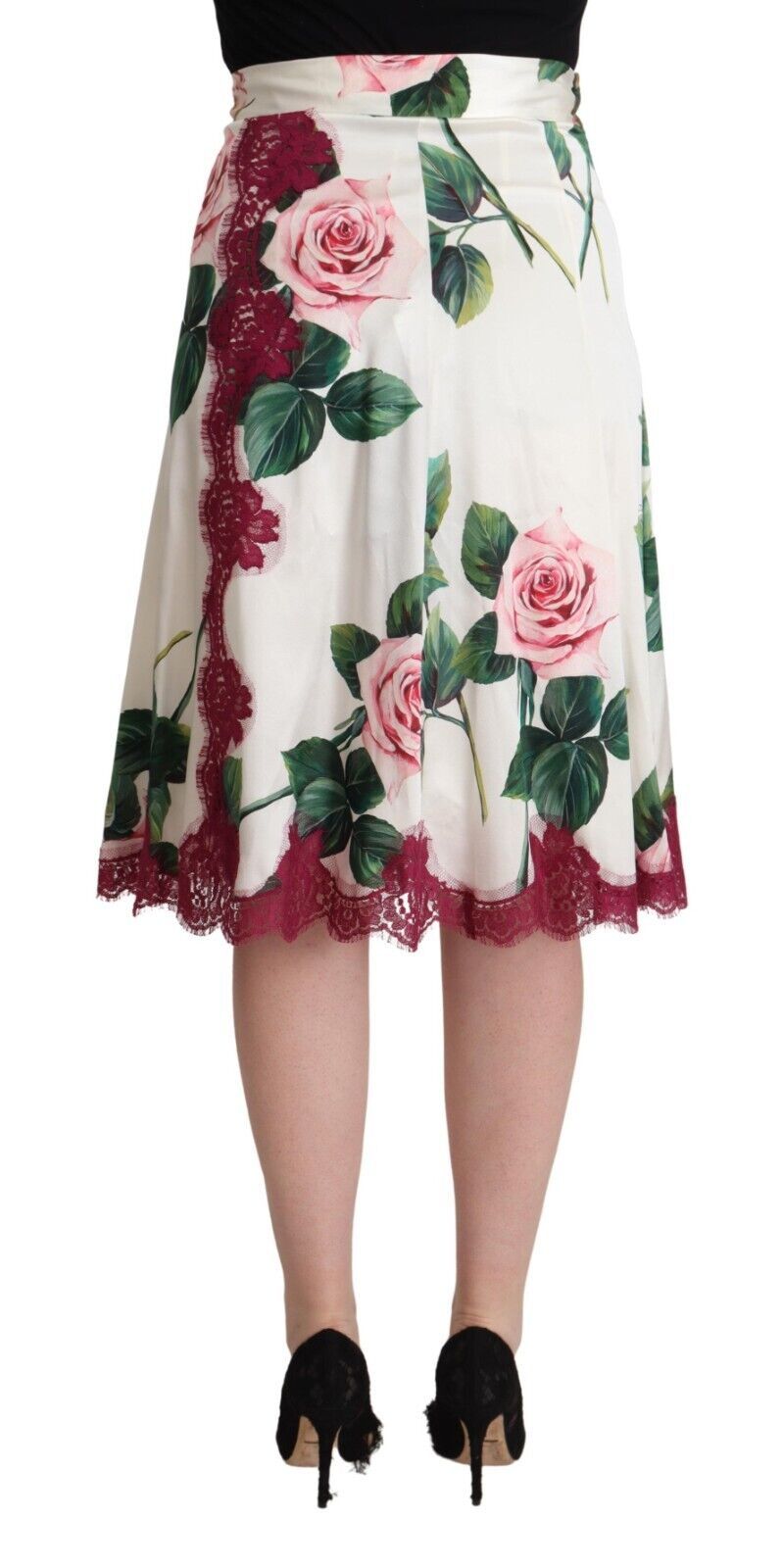 Black high heels worn by a person wearing a floral skirt
