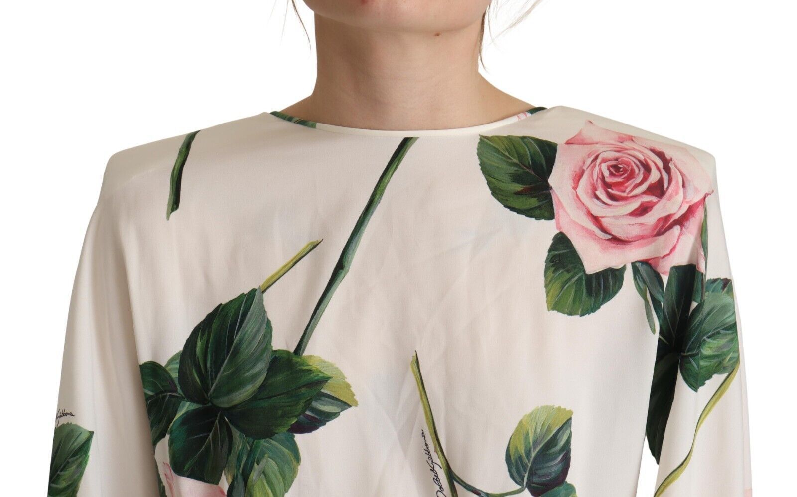 A long sleeve dress with a white rose print and green leaves on a cream background
