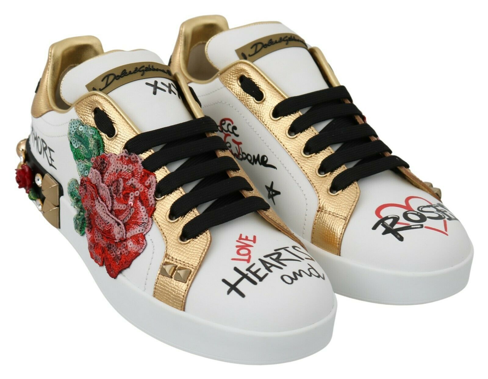 Pair of white sneakers with gold accents and floral designs on sides