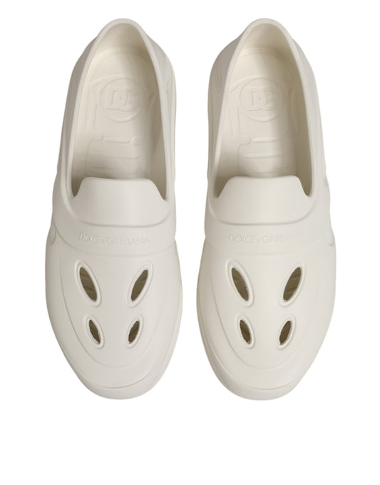 Pair of white shoes with holes in soles