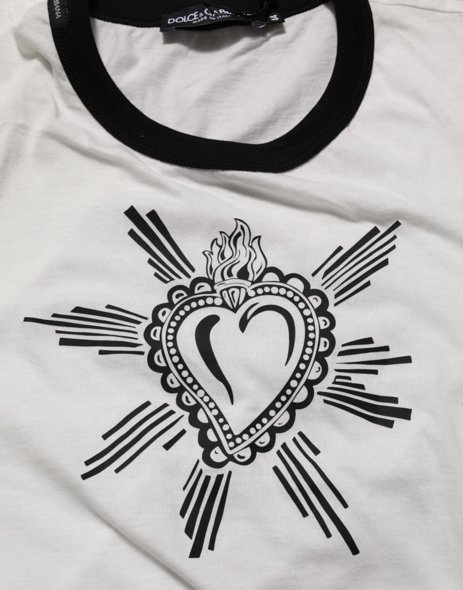 Black design on white shirt featuring heart and cross