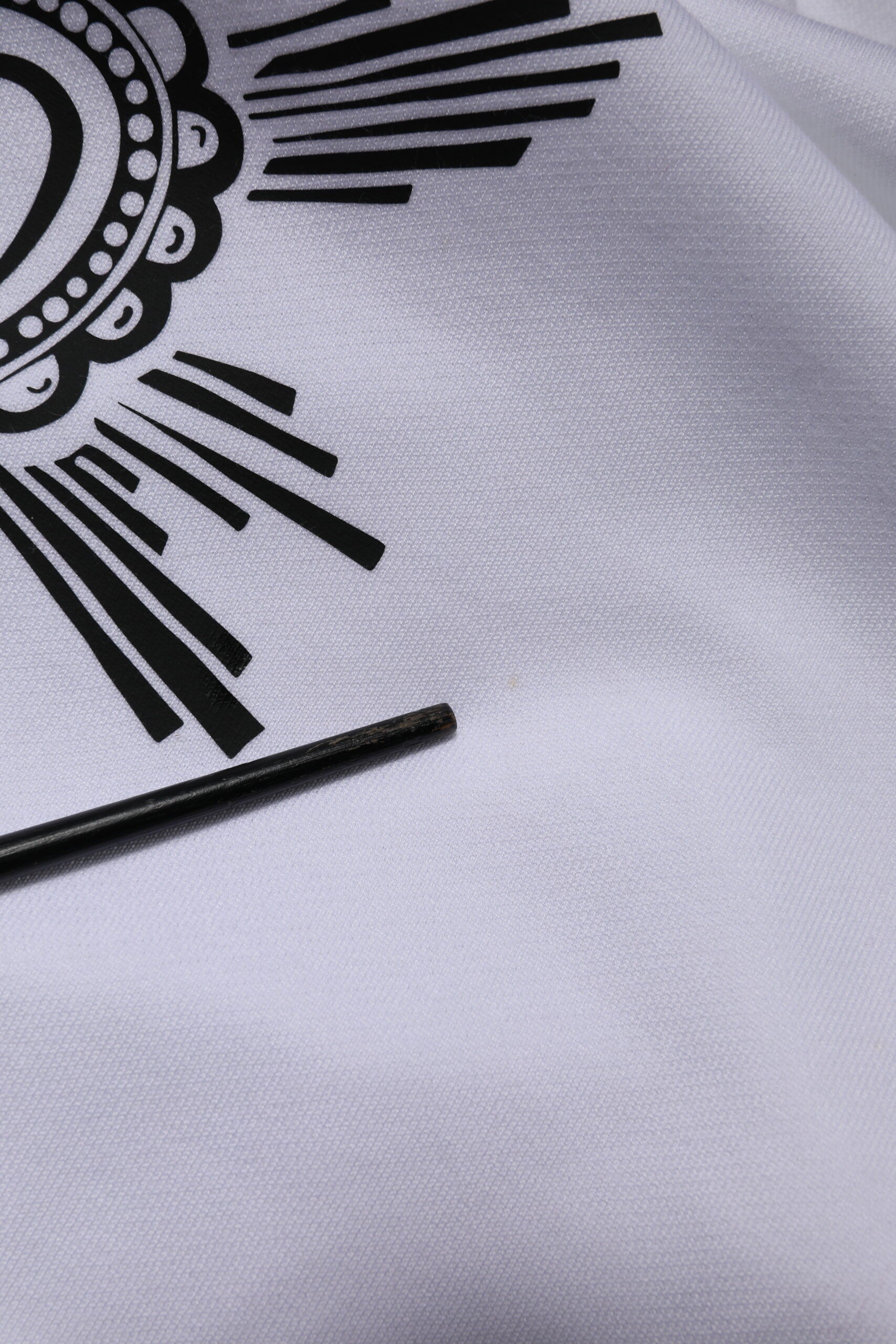 White fabric with black design and rays emanating from center