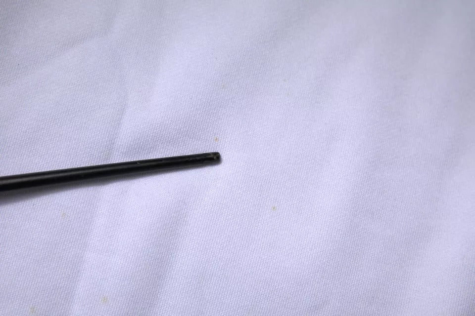 Black metal rod on white surface