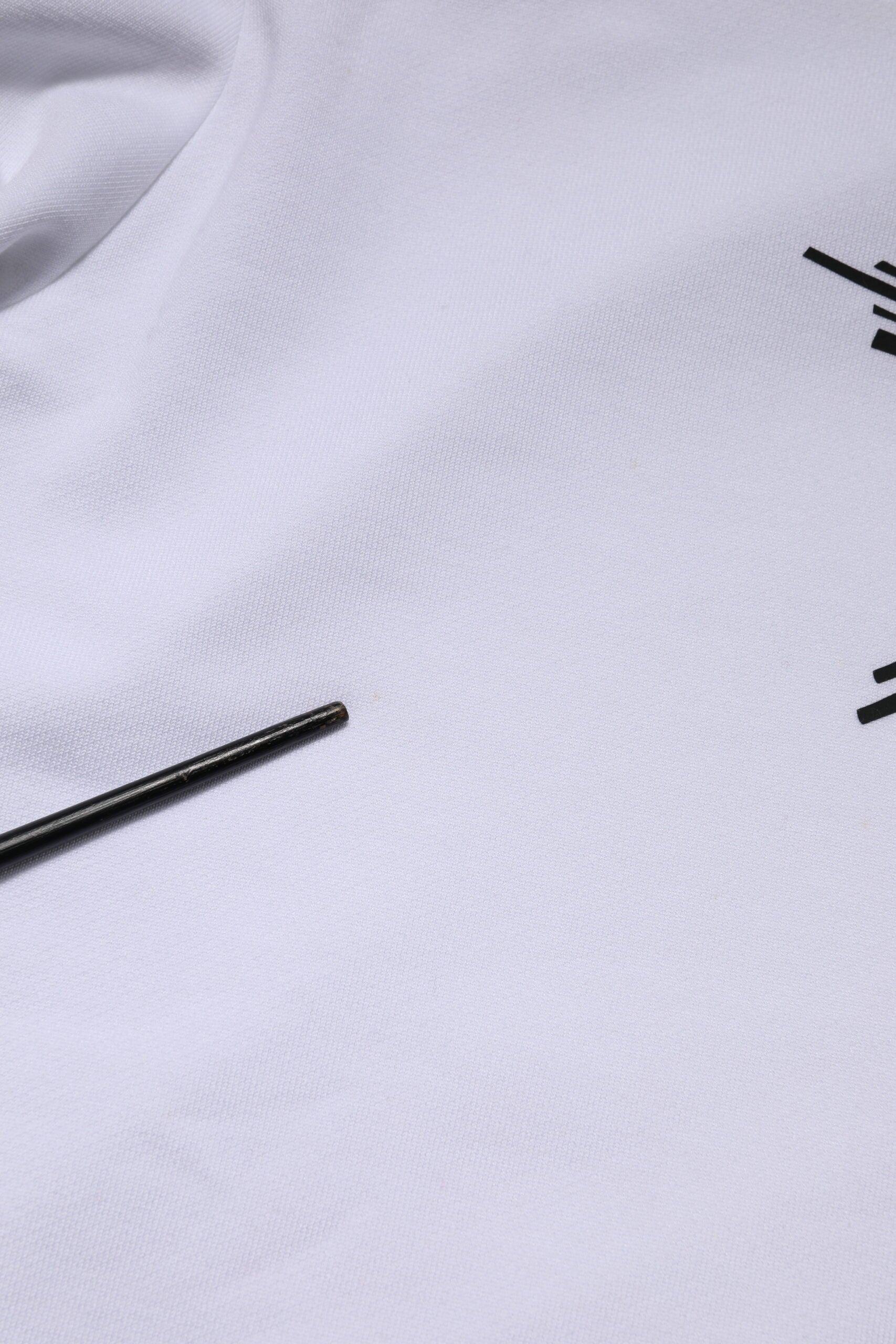 White t-shirt with black pin in fabric