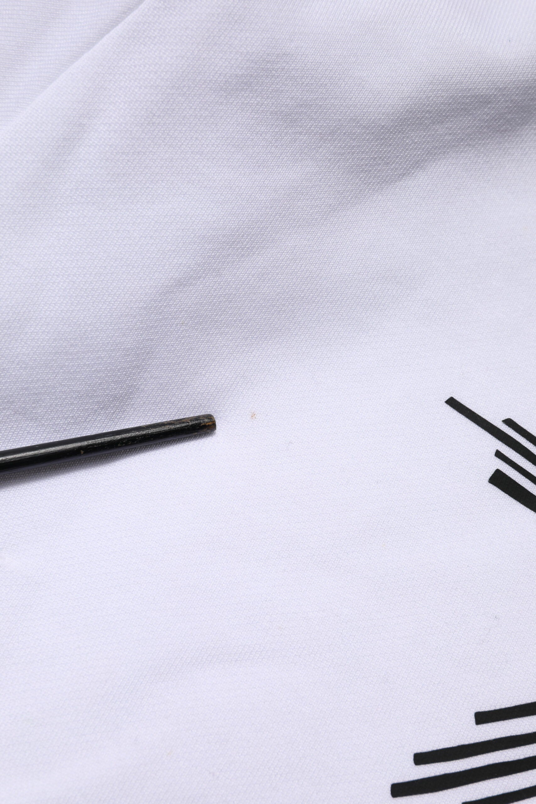 Small black metal bolt on white fabric
