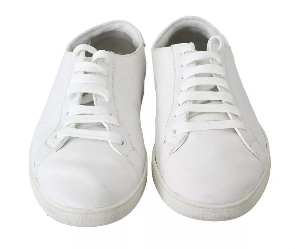 Pair of white lace-up men's sneakers with a low top and flat sole
