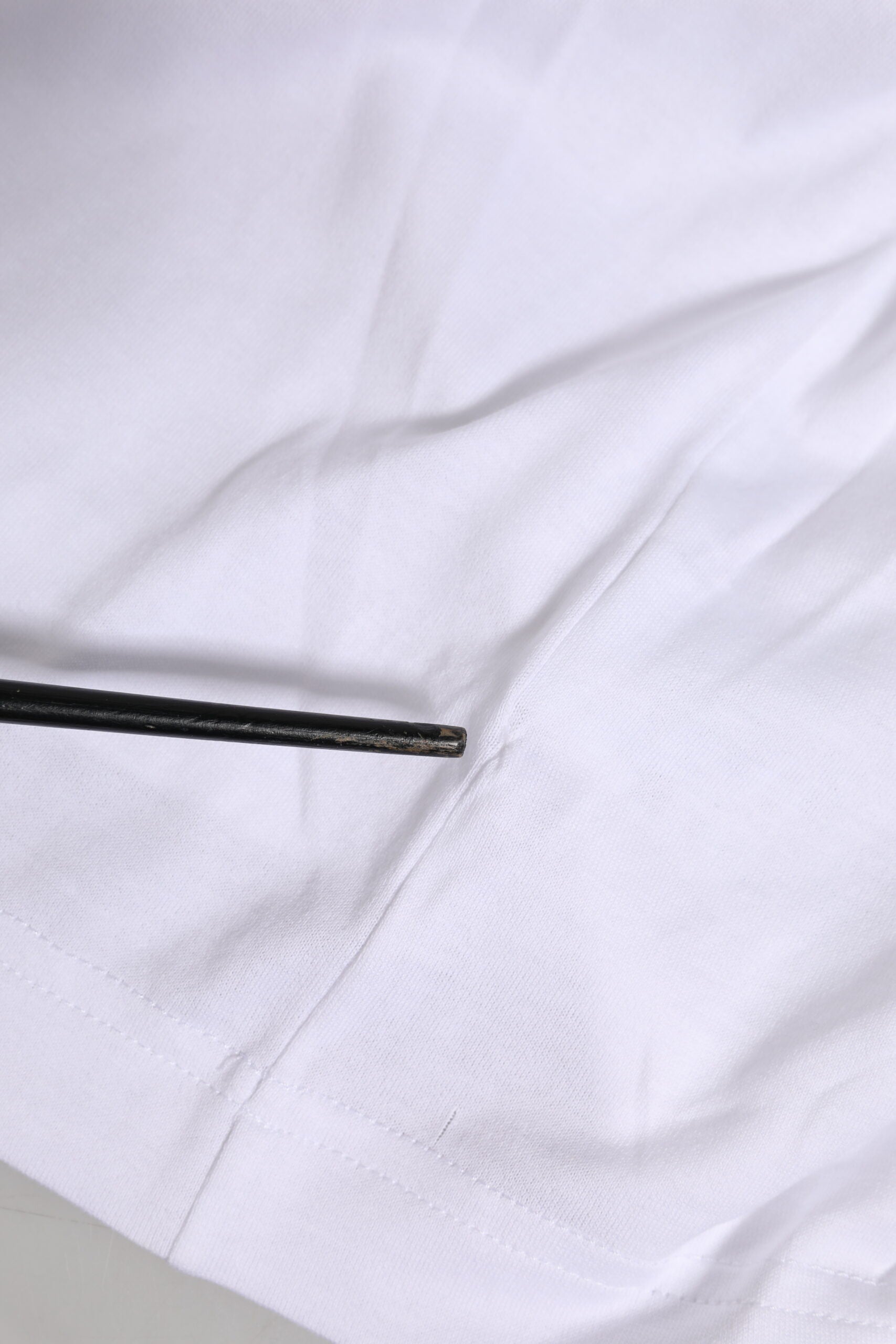 Black pin in white fabric