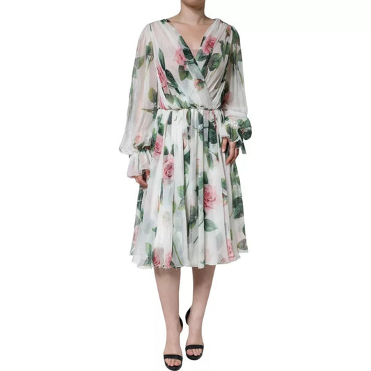 A woman wearing a white silk dress with floral print. The dress features long sleeves, a V-neckline, and a fl